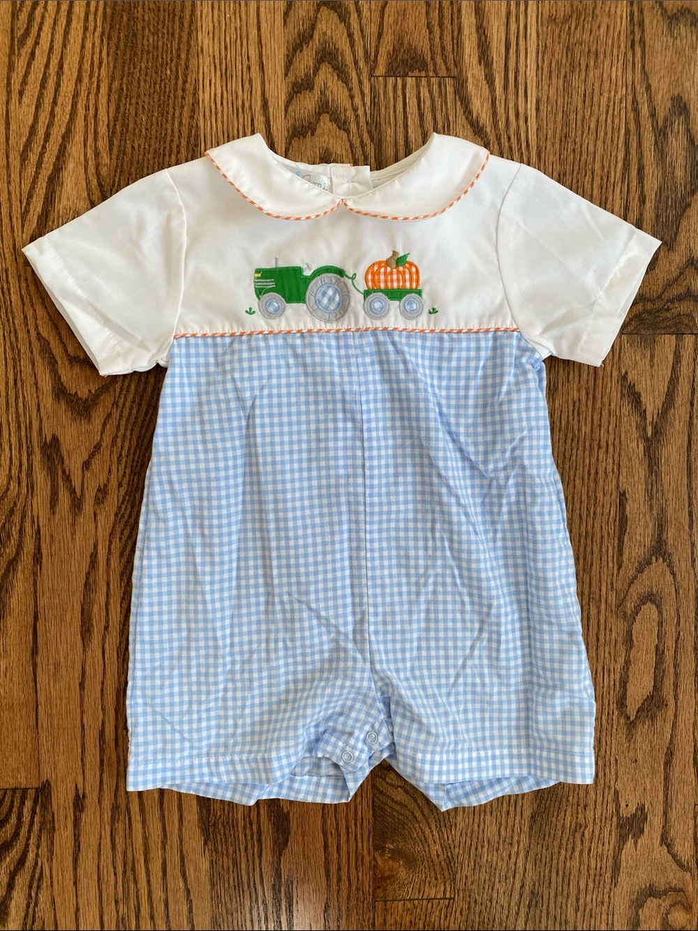 Petit Ami blue and white gingham, pumpkin tractor smocked one piece, size 12M.